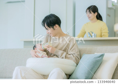 Family breastfeeding a baby on the sofa 133946640