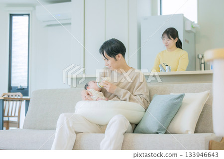 Family breastfeeding a baby on the sofa 133946643