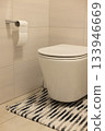 Interior of restroom with toilet bowl and carpet, tiled walls and floor. 133946669
