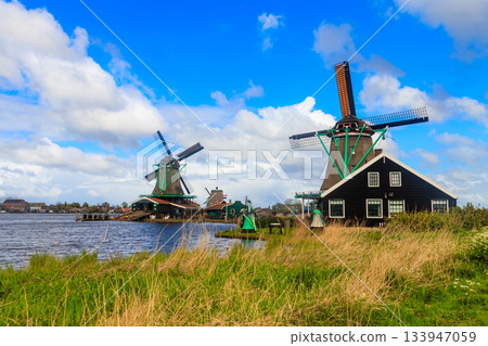 Traditional dutch windmills at the Zaan river in Zaanse Schans village, Netherlands 133947059