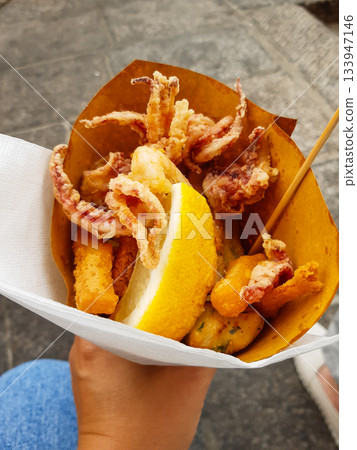 Typical Italian appetizer (Fritto misto di pesce) mix of fried seafood i female hand. Healthy snack in Genoa, Cinque Terre and Portofino Typical Italian appetizer (Fritto misto di pesce) mix of fried seafood i female hand. Healthy snack in Genoa, Cinque Terre and Portofino 133947146