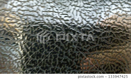 Close-up of a metallic surface with an abstract pattern. The reflective metal creates dynamic light and shadow interplay, offering a modern, textured visual for backgrounds and design elements. Close-up of a metallic surface with an abstract pattern. The reflective metal creates dynamic light and shadow interplay, offering a modern, textured visual for backgrounds and design elements. 133947425