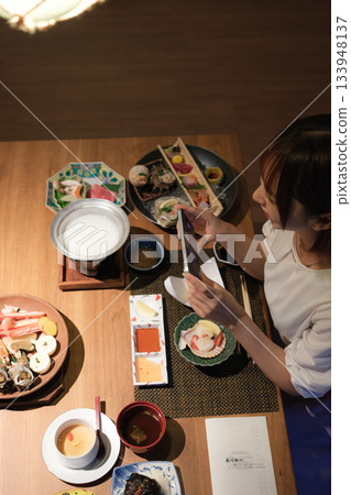 A scene of a parent and child taking a photo while enjoying a meal at a Japanese restaurant 133948137