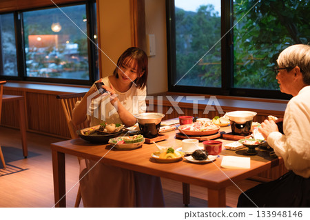 A scene of a parent and child taking a photo while enjoying a meal at a Japanese restaurant 133948146