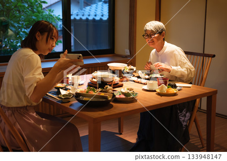 一位家長和孩子在日本餐廳用餐時拍照的場景 一位家長和孩子在日本餐廳用餐時拍照的場景 133948147