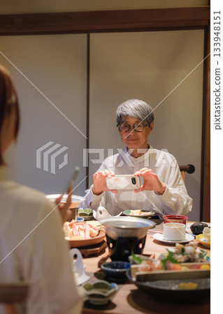 一位家長和孩子在日本餐廳用餐時拍照的場景 一位家長和孩子在日本餐廳用餐時拍照的場景 133948151