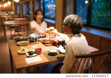 在傳統客棧裡,一家人共進晚餐,舉杯慶祝,場面溫馨感人。 在傳統客棧裡,一家人共進晚餐,舉杯慶祝,場面溫馨感人。 133948417