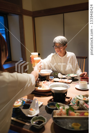 A warm moment of family toasting at dinner at a traditional inn A warm moment of family toasting at dinner at a traditional inn 133948424