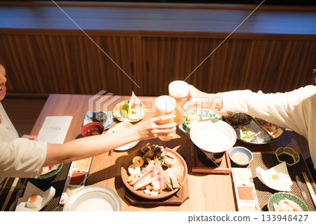 在傳統客棧裡,一家人共進晚餐,舉杯慶祝,場面溫馨感人。 在傳統客棧裡,一家人共進晚餐,舉杯慶祝,場面溫馨感人。 133948427