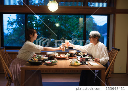 在傳統客棧裡，一家人共進晚餐，舉杯慶祝，場面溫馨感人。 133948431