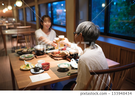 A warm moment of family toasting at dinner at a traditional inn 133948434