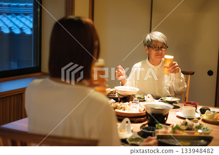 在日式旅館裡,一對父母和孩子一邊享用晚餐一邊喝啤酒,度過了一段寧靜的時光。 在日式旅館裡,一對父母和孩子一邊享用晚餐一邊喝啤酒,度過了一段寧靜的時光。 133948482