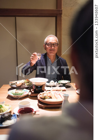 在日式旅館,一對老年夫婦在晚餐時為客人斟酒,溫馨的一幕。 在日式旅館,一對老年夫婦在晚餐時為客人斟酒,溫馨的一幕。 133948607