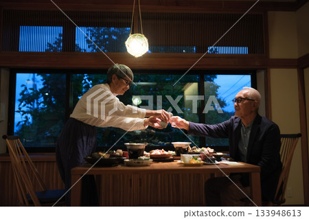 A warm moment when a senior couple pours drinks at dinner at a ryokan A warm moment when a senior couple pours drinks at dinner at a ryokan 133948613