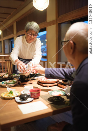 A warm moment when a senior couple pours drinks at dinner at a ryokan 133948619