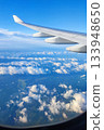 View of airplane wing above clouds on a clear sunny day with blue sky 133948650