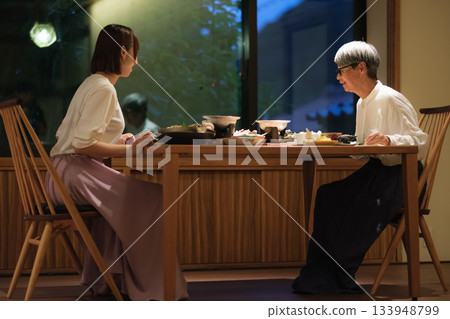A mother and daughter celebrate their 60th birthday on a trip. The two share a warm moment over a quiet dinner at a traditional Japanese inn. 133948799