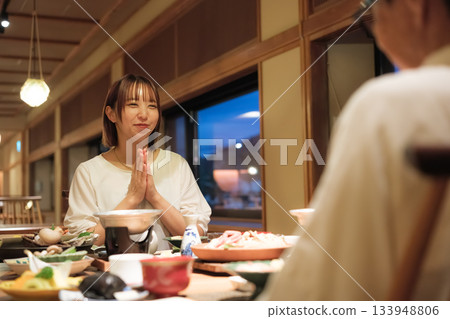 一對母女在旅途中慶祝她們的60歲生日。兩人在一家傳統的日式旅館享用安靜的晚餐，度過了一段溫馨的時光。 133948806