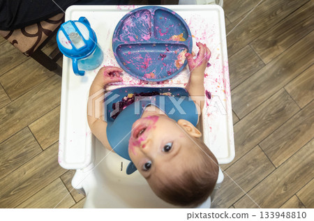Baby Playing with Food in High Chair 133948810