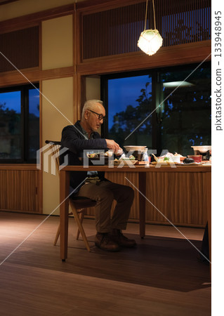 A senior couple enjoying a leisurely dinner at a traditional Japanese inn on a trip to celebrate their 60th birthday. A senior couple enjoying a leisurely dinner at a traditional Japanese inn on a trip to celebrate their 60th birthday. 133948945