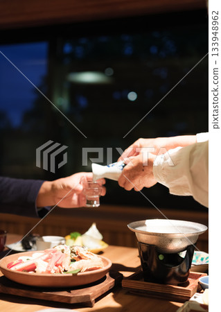 一對老年夫婦在慶祝60歲生日的旅途中,於一家傳統的日本旅館悠閒地享用晚餐。 一對老年夫婦在慶祝60歲生日的旅途中,於一家傳統的日本旅館悠閒地享用晚餐。 133948962