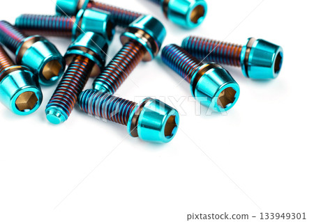 A scattering of titanium bolts in the macro are arranged on a snow-white background 133949301