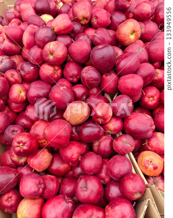 Vibrant red apples gathered at a local market showcasing autumn's harvest Vibrant red apples gathered at a local market showcasing autumn's harvest 133949556