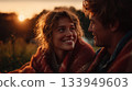 Couple enjoys cozy sunset while wrapped in a warm blanket 133949603