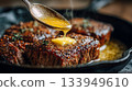 Masterful chef creating rich flavors with melted butter on savory steak 133949610