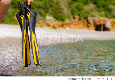 Woman with flippers swimming equipment on beach 133950123