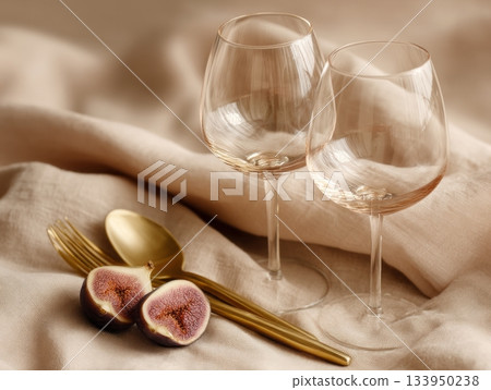 Romantic wine glasses with figs and gold cutlery 133950238