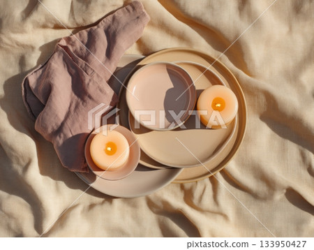 Burning candles on ceramic plates and fabric 133950427