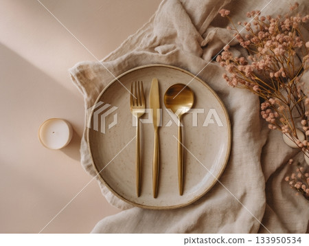 Ceramic plates with gold cutlery and linen napkin 133950534
