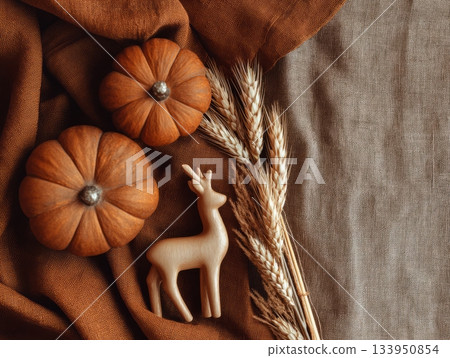 Autumn flatlay with pumpkins, dried wheat and wooden deer on linen fabric Autumn flatlay with pumpkins, dried wheat and wooden deer on linen fabric 133950854