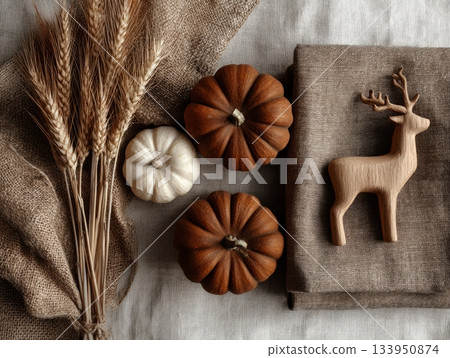 Autumn flatlay with pumpkins, dried wheat and wooden deer on linen fabric 133950874