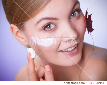 Skin care. Face of young woman girl with red maple leaf. Skin care. Face of young woman girl with red maple leaf. 133950951