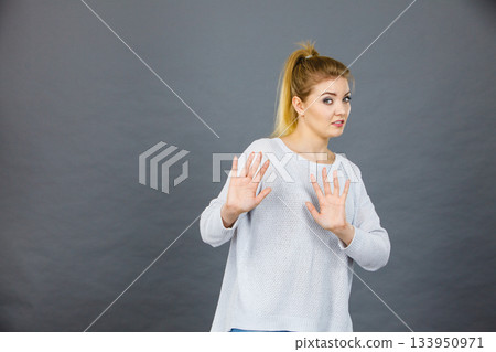 Woman deny something showing stop gesture with hands Woman deny something showing stop gesture with hands 133950971