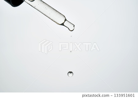 Dropping cosmetic serum from pipette illustrating beauty skincare Dropping cosmetic serum from pipette illustrating beauty skincare 133951601