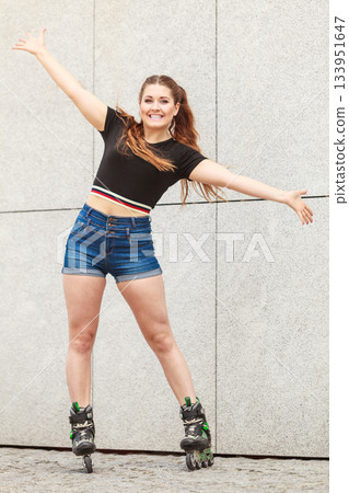 Young woman riding roller skates Young woman riding roller skates 133951647