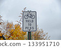 Bicycle yield sign with autumn trees in background Bicycle yield sign with autumn trees in background 133951710