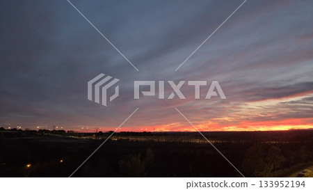 Stunning city sunset with vibrant sky and silhouette of urban landscape 133952194