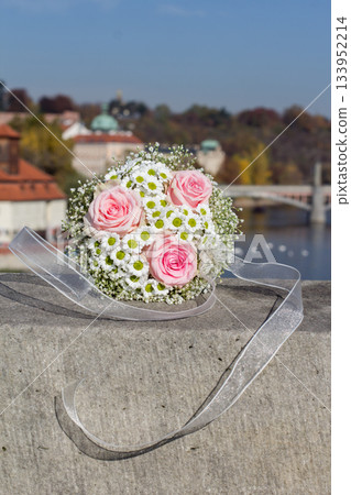 Wedding bouquet resting on stone wall overlooking prague cityscape 133952214