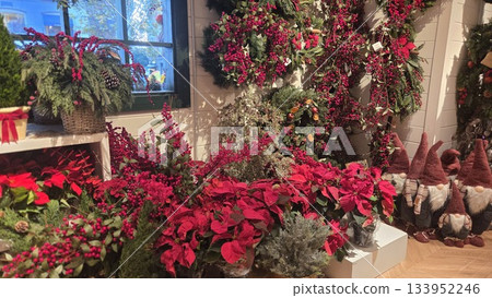 Festive Christmas floral arrangement with poinsettias and holiday decorations Festive Christmas floral arrangement with poinsettias and holiday decorations 133952246