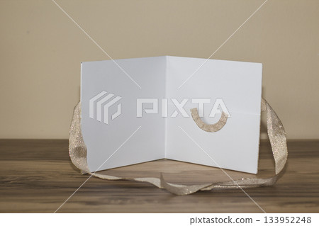 White wedding favor box with gold ribbon on wooden table White wedding favor box with gold ribbon on wooden table 133952248