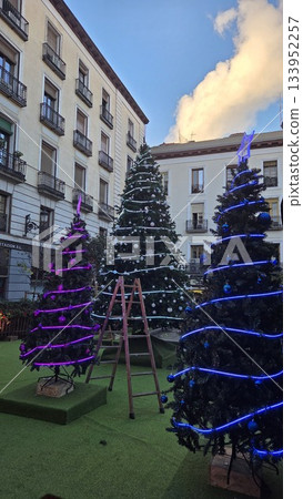 Festive christmas trees with colorful lights in urban setting 133952257