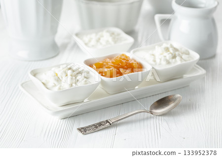 Cottage cheese with cream and yellow jam. 133952378