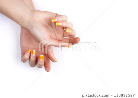 Beautiful Female Hands with bright orange Manicure like Candy Corn. Manicured Nails with Yellow Gel Polish. Halloween Style Beautiful Female Hands with bright orange Manicure like Candy Corn. Manicured Nails with Yellow Gel Polish. Halloween Style 133952587