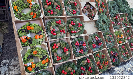 Colorful Christmas wreaths display with pinecones and berries on a Christmas market 133952842