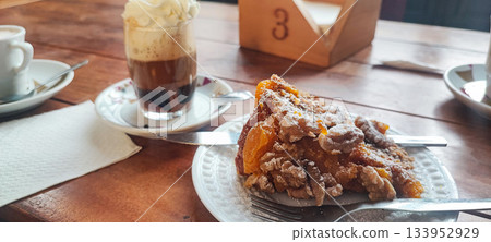 A close-up of a glass of hot coffee with cream and a fruit nut pie. Concept: coffee break, hospitality, and homemade baked goods. 133952929
