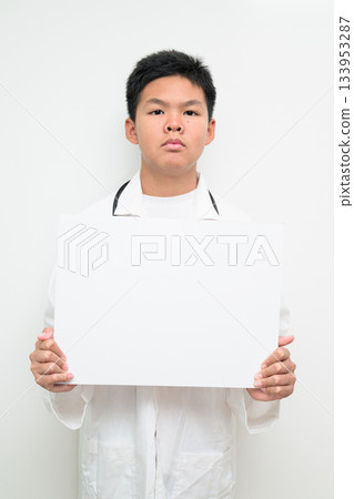 Young Asian Boy Dressed as Doctor with Stethoscope Showing Empty Placard with Copy Space 133953287